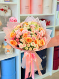 Peach and pink rose bouquet with pastel wrapping for flower delivery in Los Angeles
